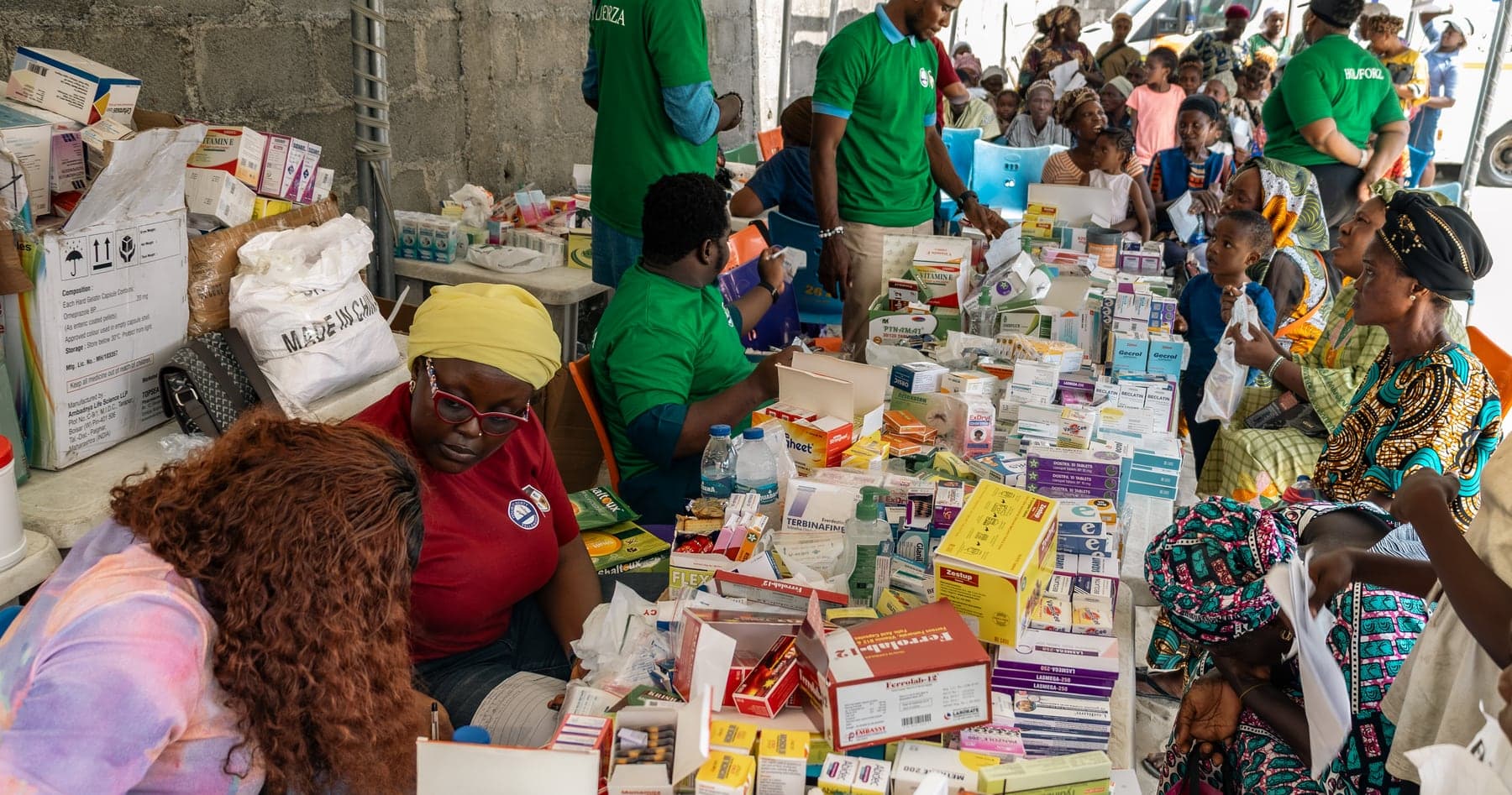 Volunteers working along tables covered with boxed medicines at the dispensary.