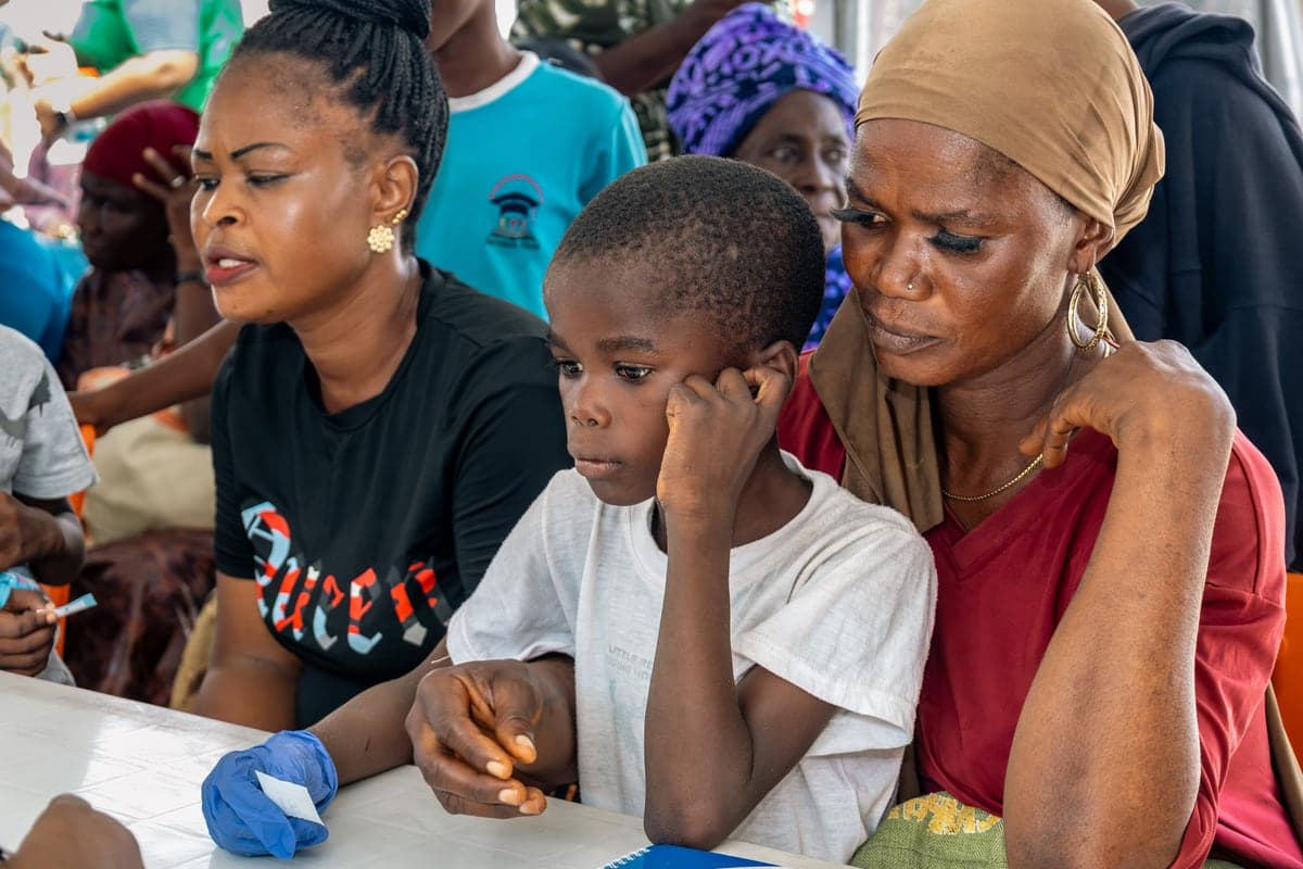 A woman, a child and a second woman at the registration desk.