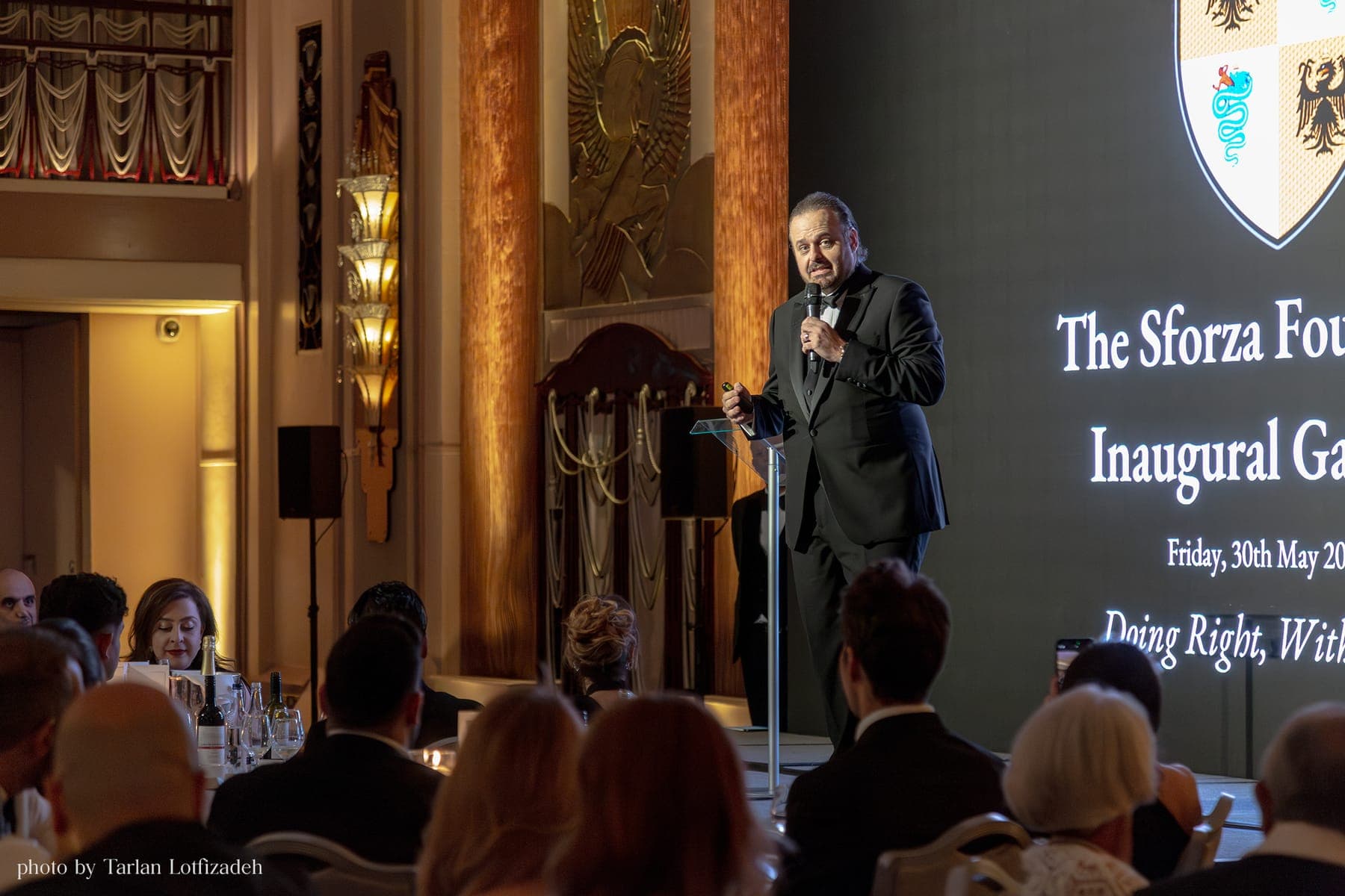 A speaker addressing the room, with the Foundation's Inaugural Gala Ball title projected behind.